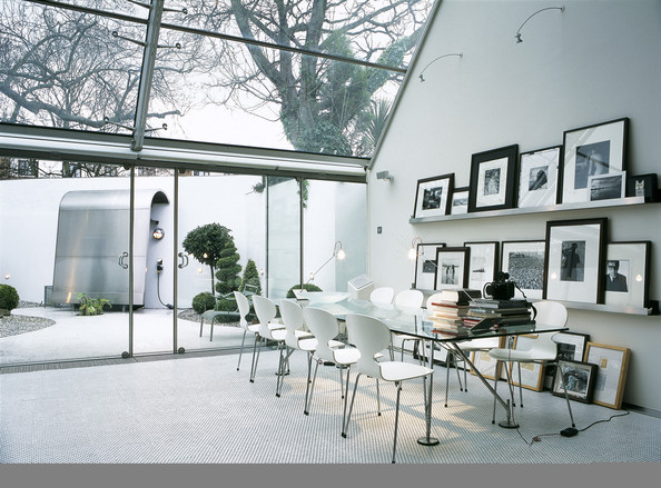 Univers très graphique avec une table de repas en verre et des chaises fourmi signées Arne Jacobsen
