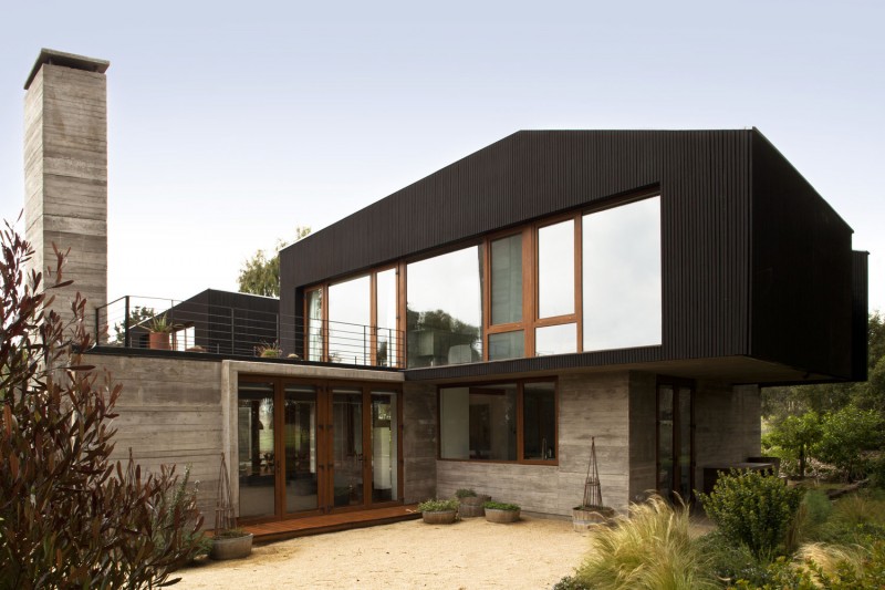 Une maison contemporaine en bois noir et béton brut